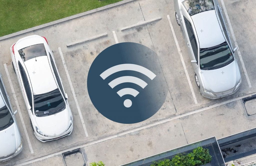 Cars parked in a parking lot, includig an icon to depict a Wi-Fi symbol